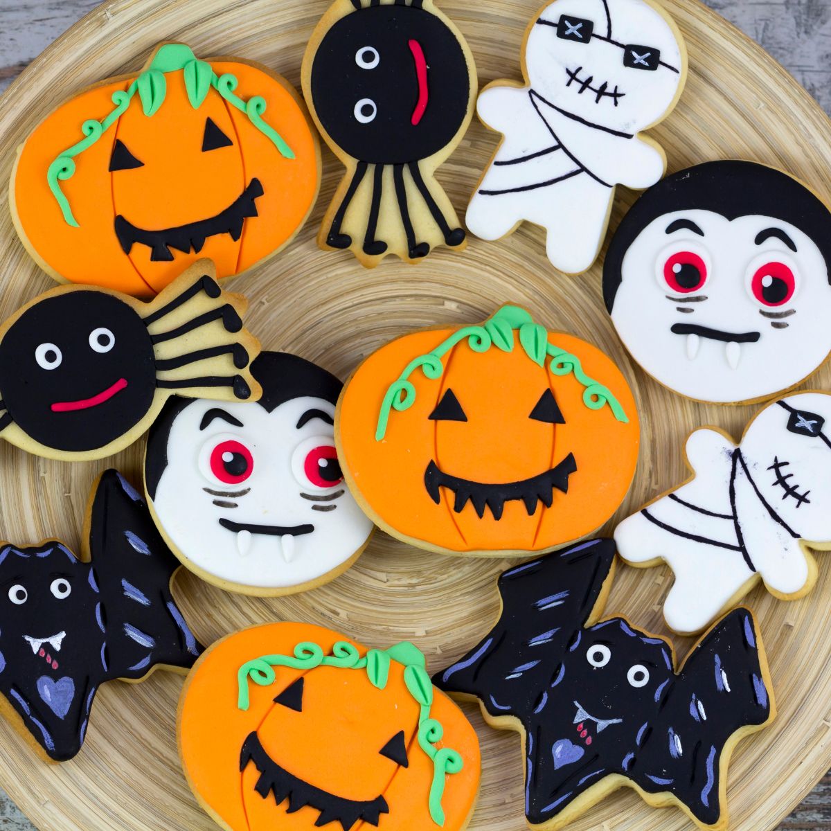 Halloween frosted cookies on a plate. Includes pumpkins, spiders, mummies and dracula.