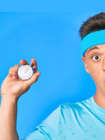 Boy on blue background holding stopwatch