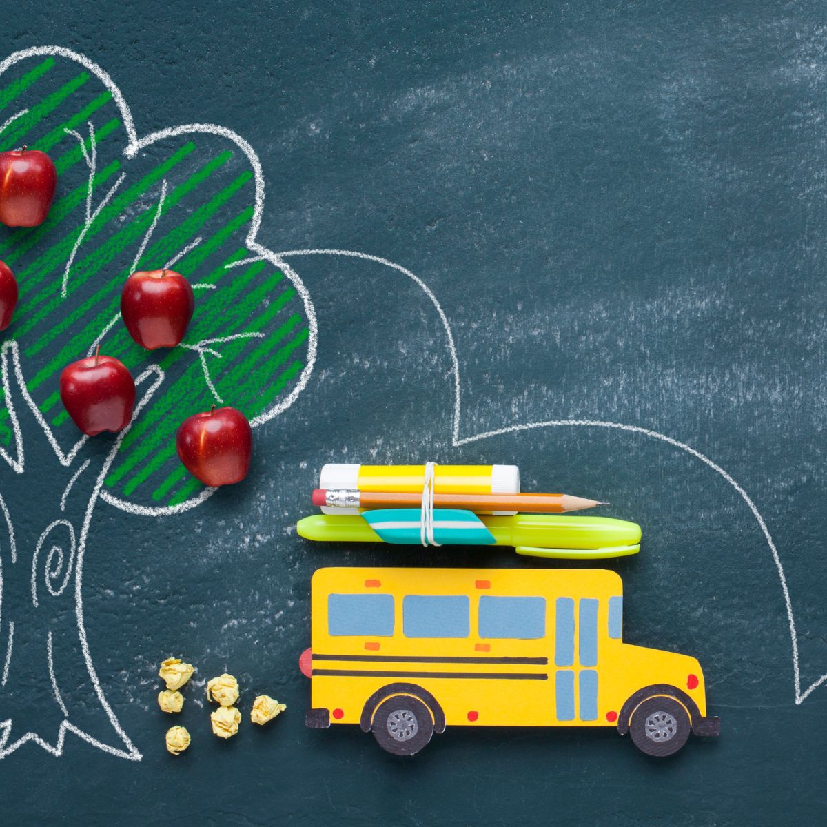 School bus on chalkboard with apple tree