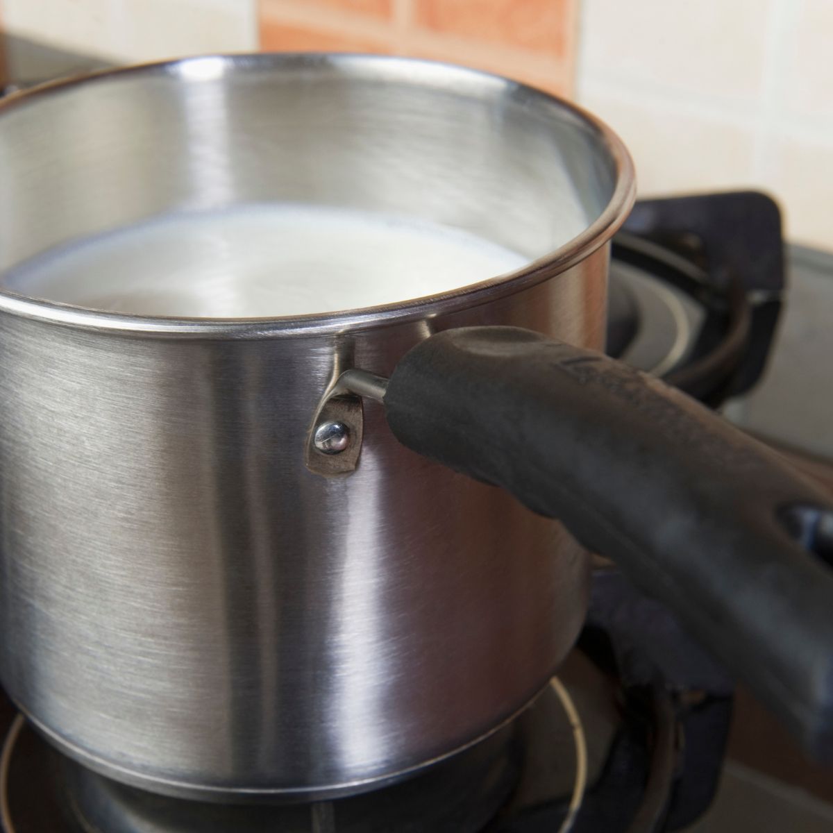 Milk being heated in a small saucepan on the stove