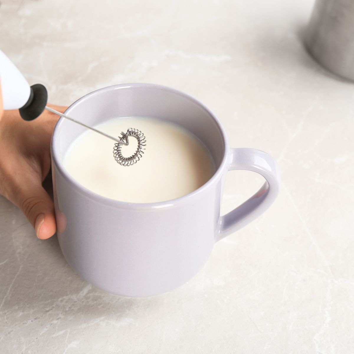 Milk in a white mug with a milk frother