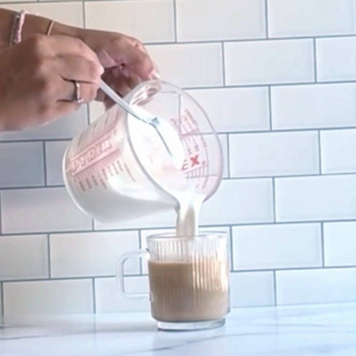 Adding warm milk to a latte.