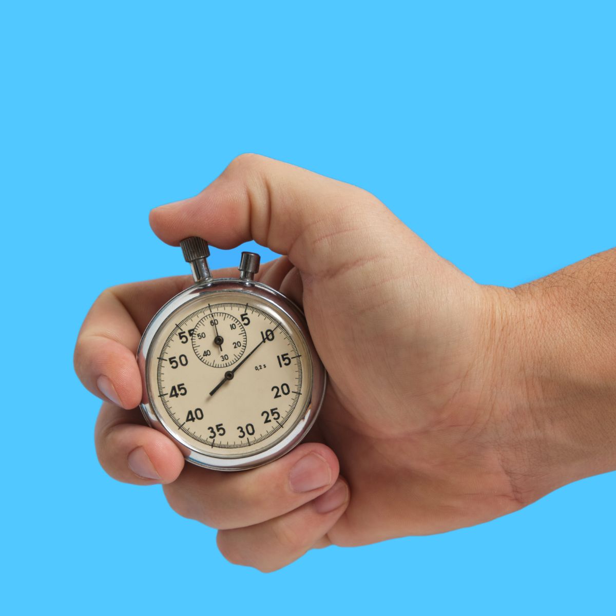 Hand holding stopwatch on blue background
