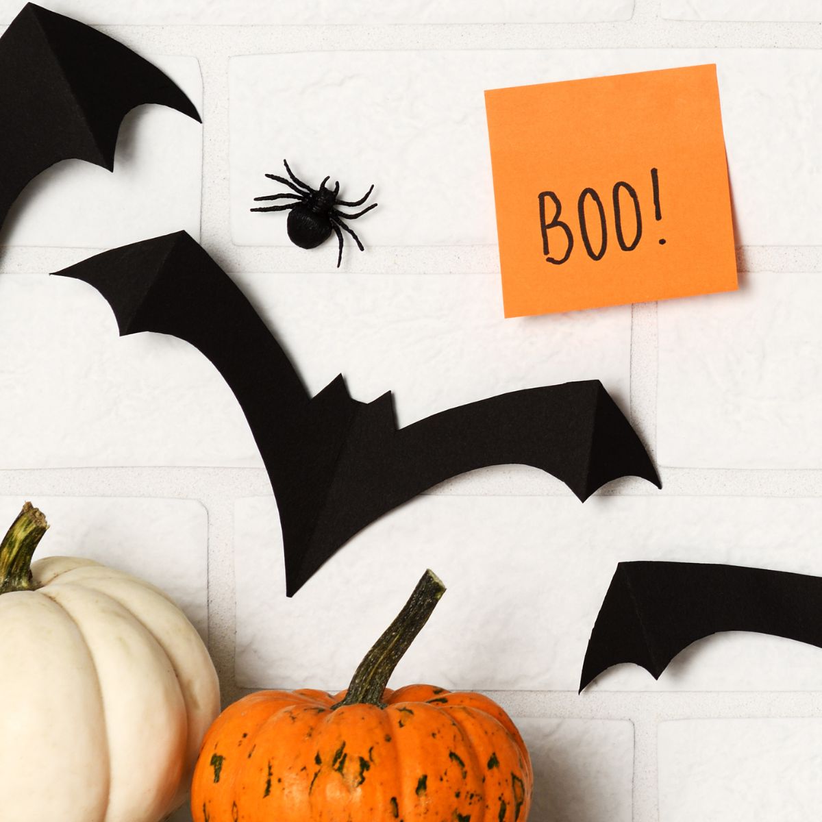 Bats and pumpkins against white backdrop with a post it note that says BOO!