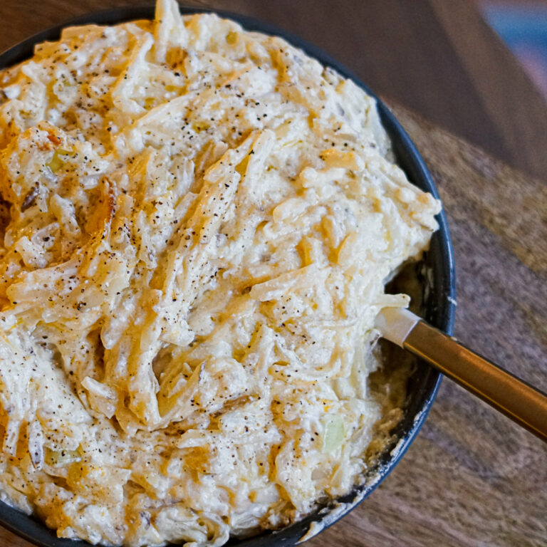 Cracker Barrel Cheesy potatoes recipe in cast iron skillet with spatula on side