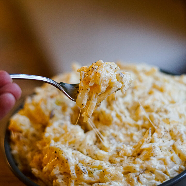 Cracker Barrel Cheesy potatoes recipe with a fork pulling up a bite.