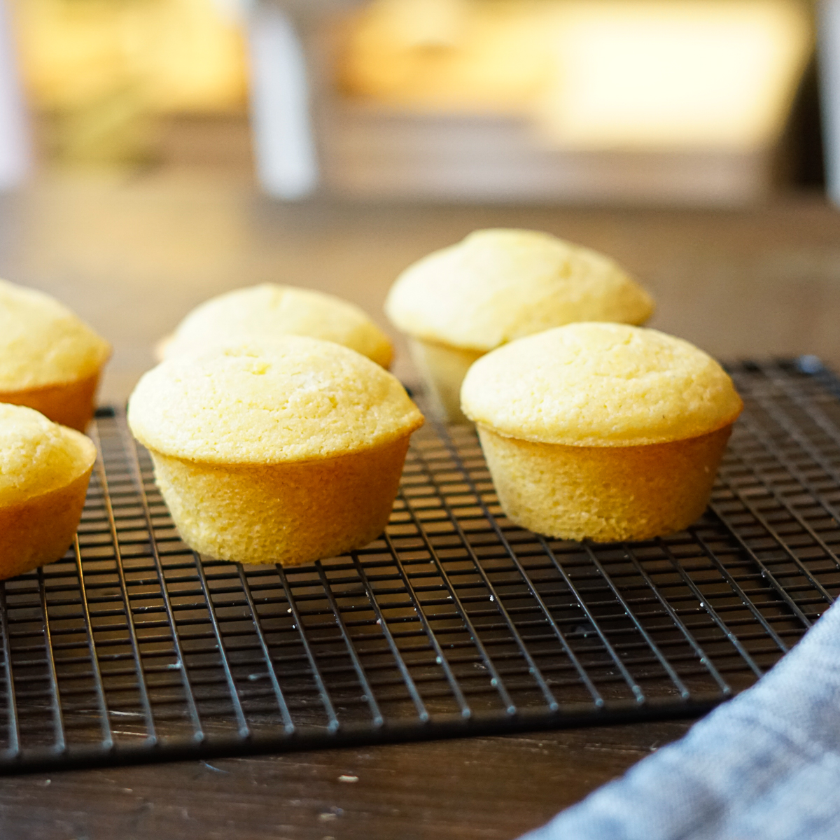 Side view of Cracker Barrel Cornbread Muffins on a wire rack with a blue potholder