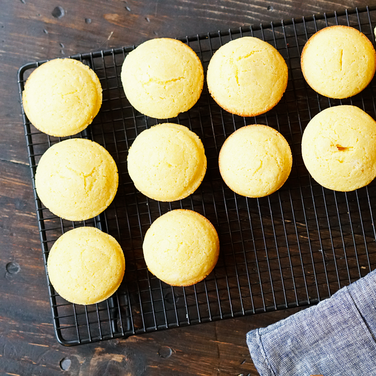 10 Cracker Barrel Cornbread Muffins on a wire rack with a blue potholder