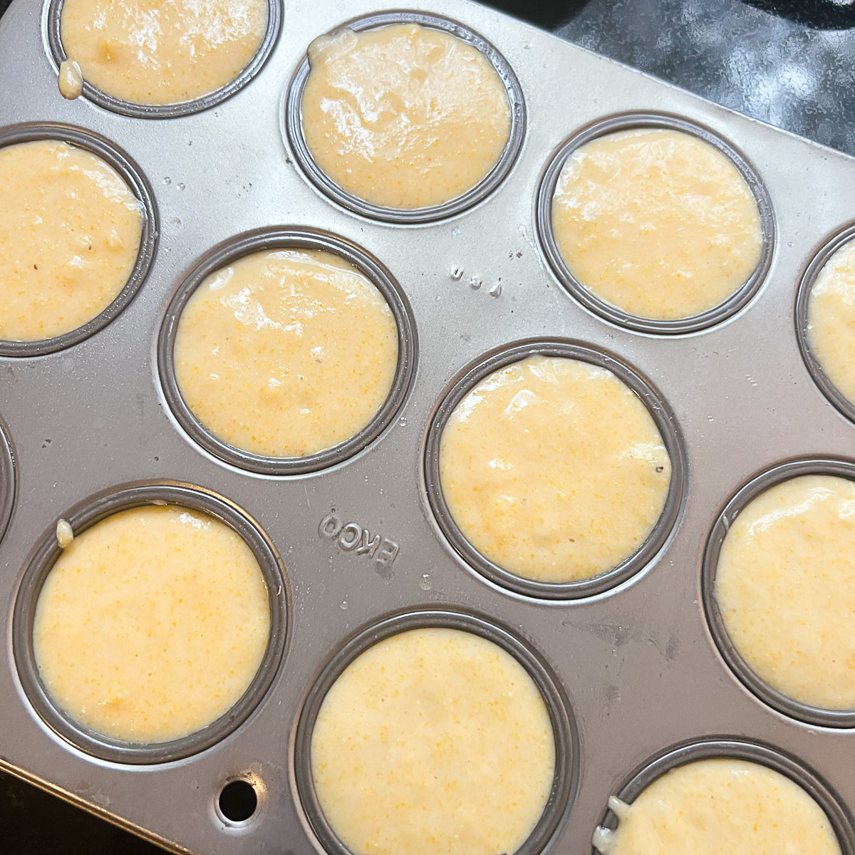 Dairy Free Cracker Barrel Cornbread Muffins batter in a muffin tin ready to be baked in a preheated oven