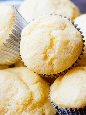 Gluten Free Cracker Barrel Cornbread Muffins in a pile with tin foil wrappers