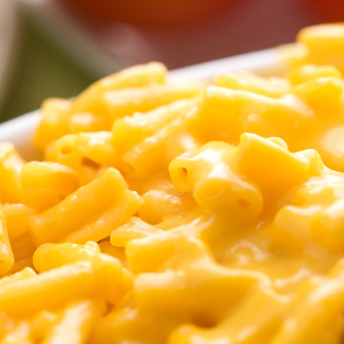 Orange and cheesey macaroni and cheese in a white bowl