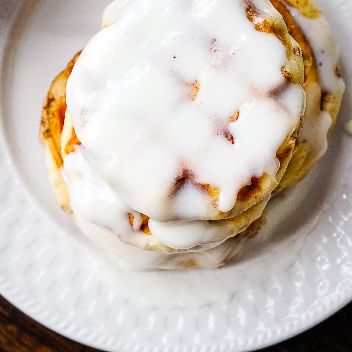 cinnamon roll waffles with frosting on top with white plate